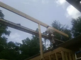 Carpenter setting a ridge beam over a new addition frame — Ice Dam Removal by Roofing Brothers in Big Stone Gap