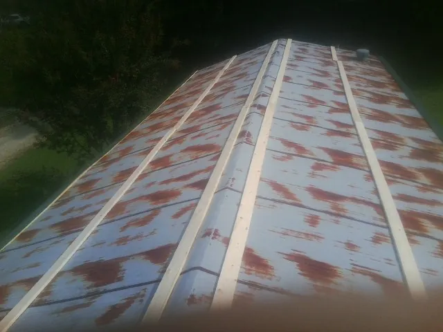 Rusted metal roof panels with new wood purlins before replacement — Storm Damage Roof Repair in Big Stone Gap by Roofing Brothers