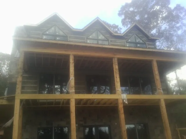 Dormers and porch framing on a large log home under construction — Roof Coating work by our crew in Big Stone Gap