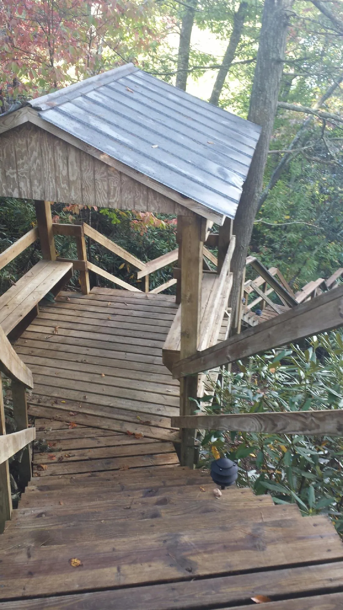 Metal roofed shelter over wooden steps on a wooded walkway — Skylight Repair & Installation work by our crew in Big Stone Gap