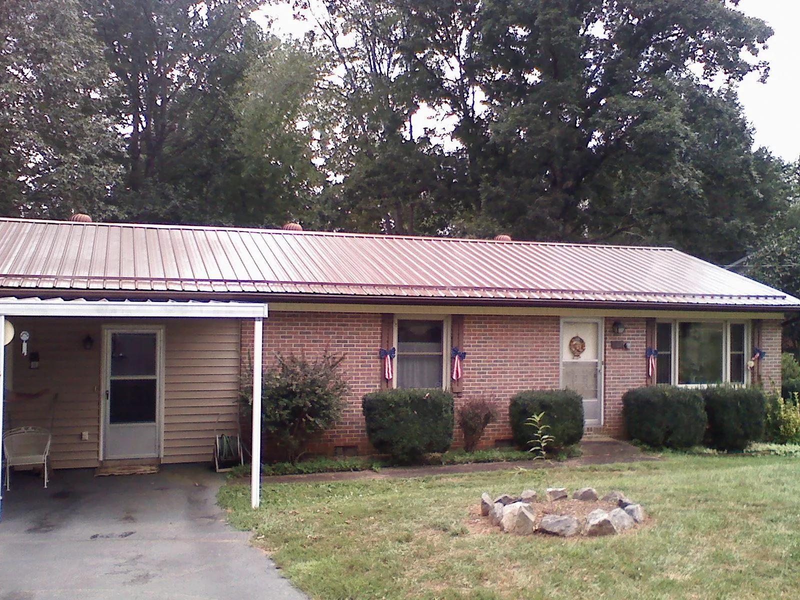 Bronze metal roof and carport on a brick ranch home — Roof Repair work by our crew in Big Stone Gap
